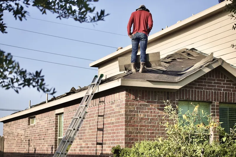 Professional roofer working on a residential roof in Watkins